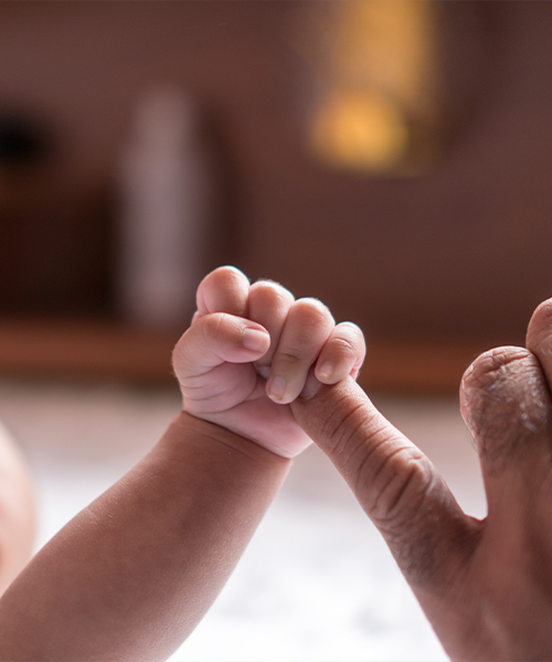baby holding someones finger